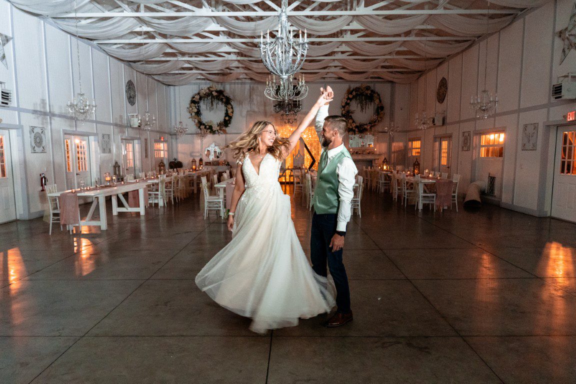 The couple dancing alone in the Manor Barn, the floor cleared and the chandelier lit