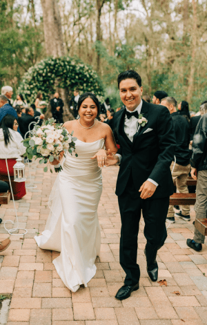Bride and groom walking back up the brick aisle after the ceremony, guests still seated