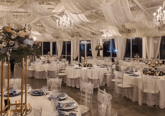 Indoor reception set with round tables and warm lighting at Saxon Manor, ready as a weather backup